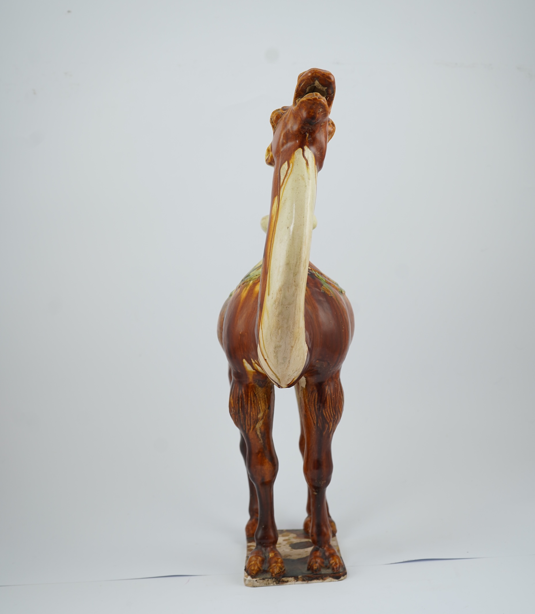 A large Chinese sancai pottery figure of a bactrian camel, Tang dynasty